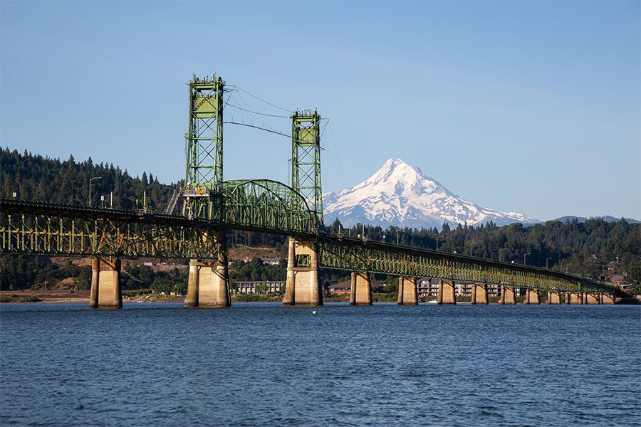 St. Helens, OR - View of a Bridge Across a River in St Helens Oregon with a Snow Capped Mountain in the Background Against a Clear Sky